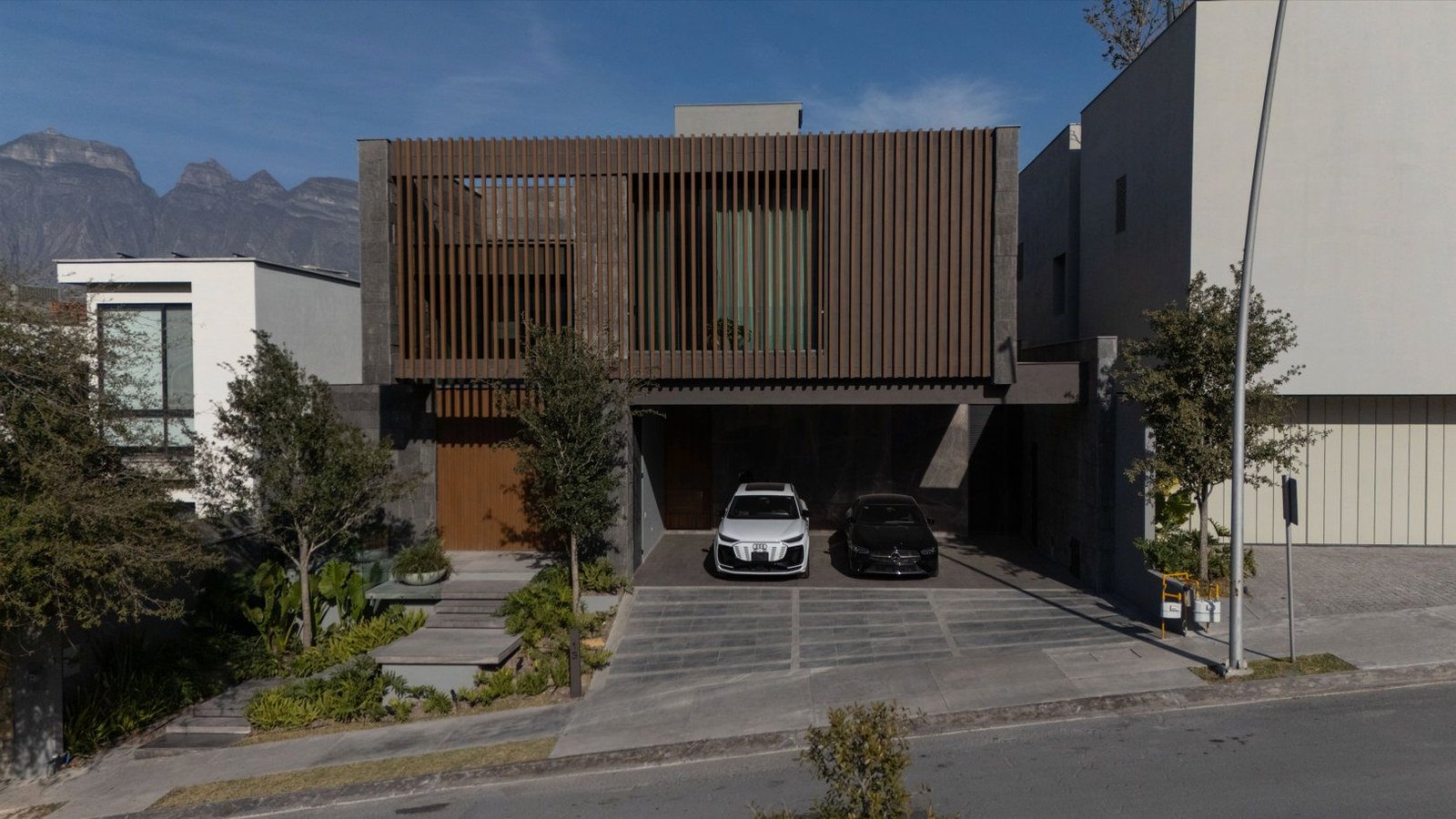 Fachada de residencia contemporánea en Monterrey con la Sierra Madre al fondo